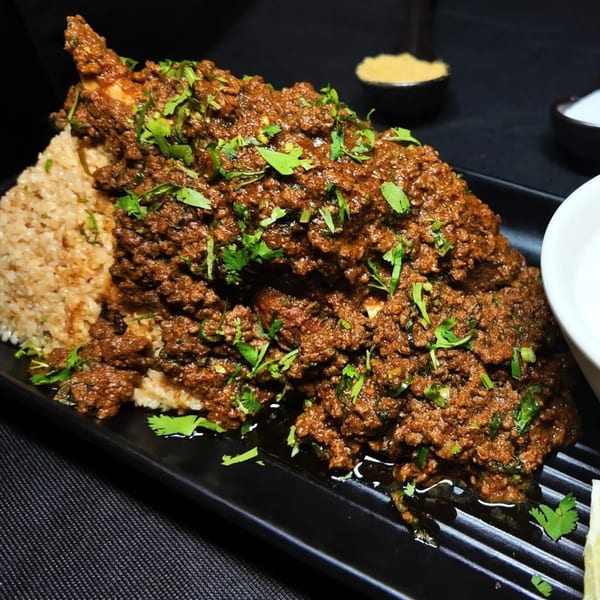 Amrut Fusion's Asian-fusion dish with brown rice and a rich, dark meat curry topped with fresh cilantro.